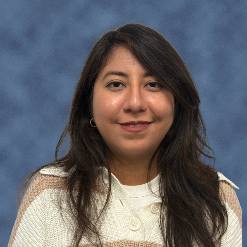 A person with long hair in a striped buttoned sweater